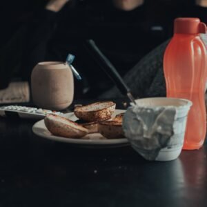 sliced bread on white ceramic plate beside orange plastic bottle